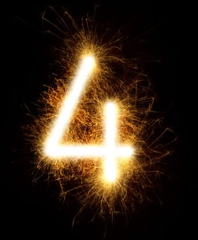 Number 4 drawn with spaklers on a black background