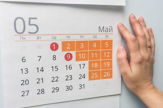 Hand next to the wall calendar