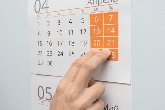 Two fingers point on the weekend in the wall calendar
