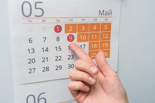 The hand points to the long May holidays holiday in the wall calendar