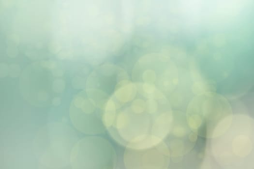 Abstract blurred light green pastel background texture with bright bokeh circles.