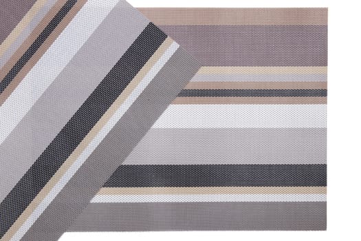 Plastic mats backgrounds. Two woven plastic mats with a colorful striped pattern isolated on a white background.