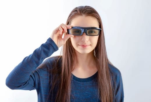 Smiling teenager girl with 3d glasses looking at camera on white background. Watching a movie concept.