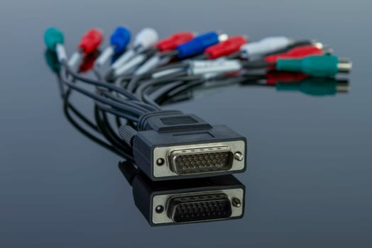 Tv audio video cable connector with multiples connections on black glossy background.