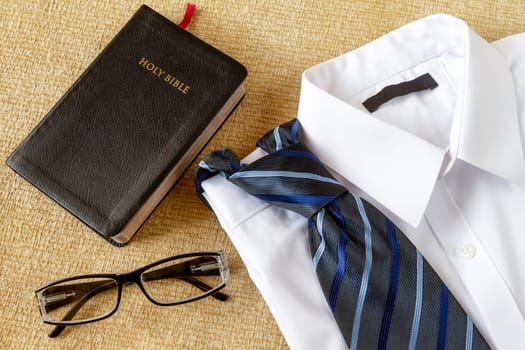 Man shirt with tie and Holy Bible with glasses. Ready to go at church concept.