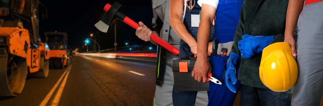 Builder workers with equipment repairing a road in night city