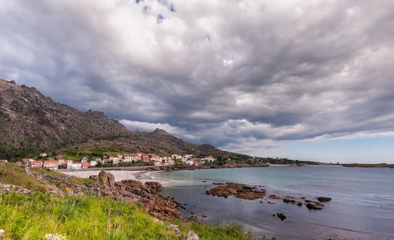 Beauty Atlantic coast with cliff, beach, ocean, village and sky with clouds. Galicia, Spain.