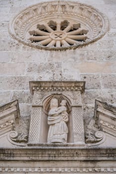 Sculpture of Mary holding baby Jesus on the front wall of the basilica of Our Lady of the Rocks in Kotor Bay, Perast, Montenegro.