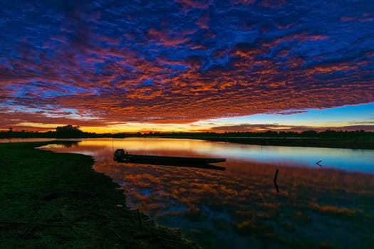 Sunrise With Lake Reflection, idyllic landscape with boat and cumulus clouds
