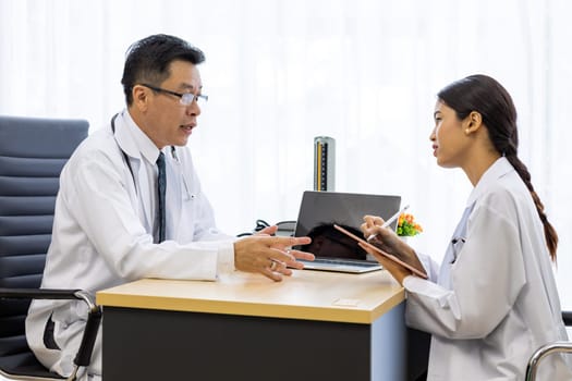 Two doctors in the hospital discuss the diagnos of the patient