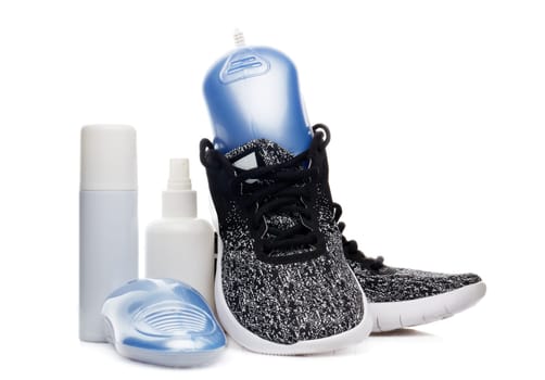 Sports shoes care. Electric shoes dryer with UV sterilization on a white background, Deodorant for shoe and antifungal agent. Shoe care products. Concept of healthy feet. Fitness and sport footwear