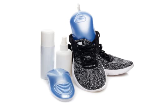 Sports shoes care. Electric shoes dryer with UV sterilization on a white background, Deodorant for shoe and antifungal agent. Shoe care products. Concept of healthy feet. Fitness and sport footwear