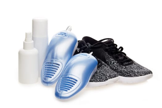 Sports shoes care. Electric shoes dryer with UV sterilization on a white background, Deodorant for shoe and antifungal agent. Shoe care products. Concept of healthy feet. Fitness and sport footwear
