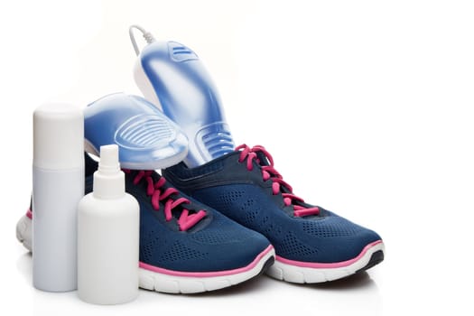 Sports shoes care. Electric shoes dryer with UV sterilization on a white background, Deodorant for shoe and antifungal agent. Shoe care products. Concept of healthy feet. Fitness and sport footwear