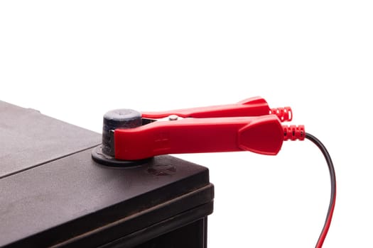 Black car accumulator battery and charger isolated on a white background. Acid battery,12 volts supply. Concept of service, maintenance, charging car battery, diy