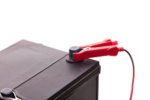 Black car accumulator battery and charger isolated on a white background. Acid battery,12 volts supply. Concept of service, maintenance, charging car battery, diy