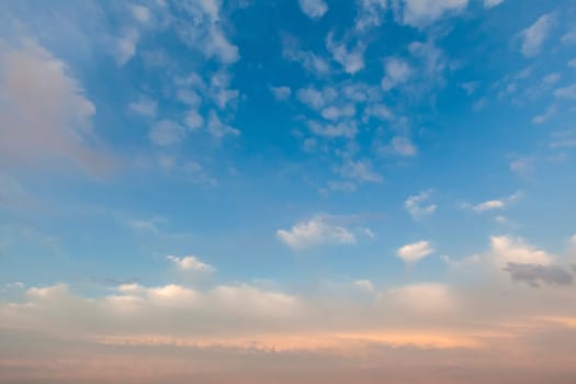 Soft pink cloudscape at sunset in the UK over Norfolk. Blue sky and white fluffy clouds