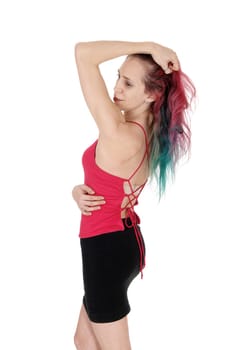 A slim young woman standing in a black skirt and red top with her red.hear with one hand on her head, isolated for white background.