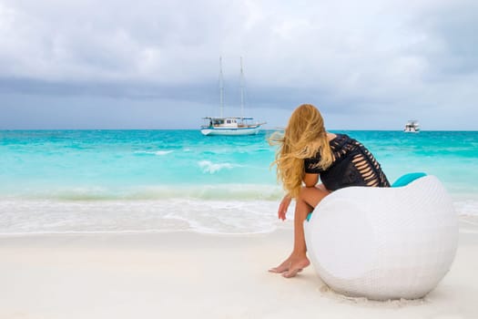 Lonely girl in the wind sitting by the sea