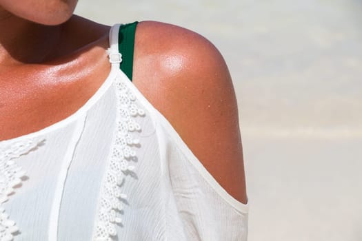 Woman shoulder under the sun at the dream beach