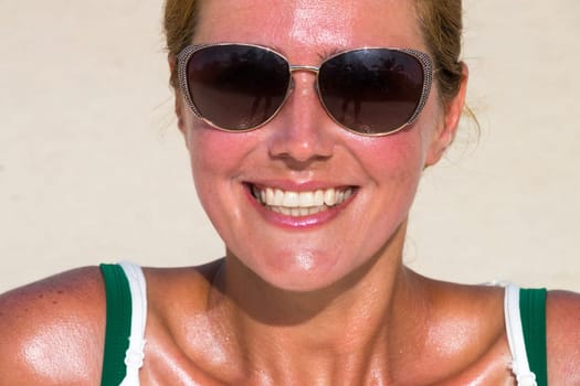 Beautiful woman in sunglasses tans at the dream beach