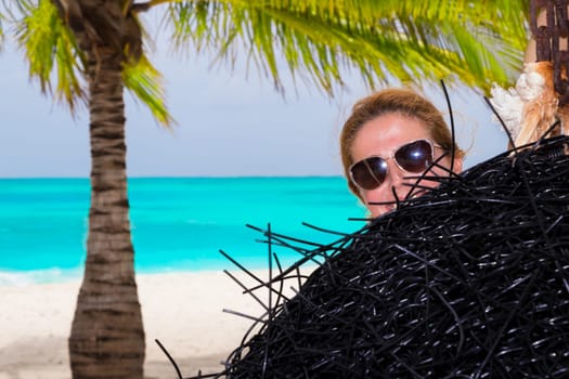 Beautiful woman relaxes on a swing on the dream beach