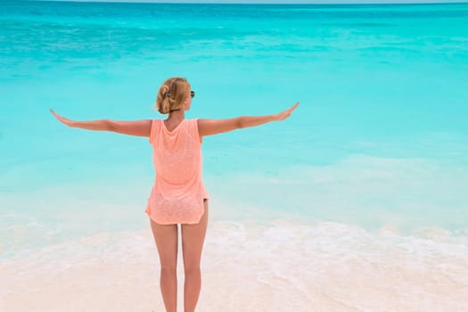 Gorgeous woman on the sandy beach with turquoise ocean