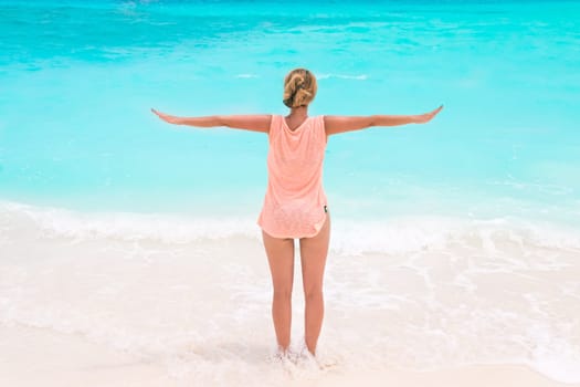 Gorgeous woman on the sandy beach with turquoise ocean