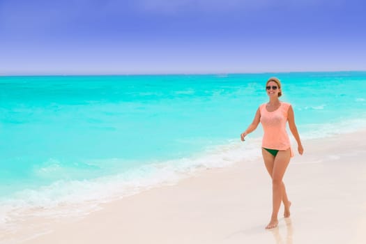 Gorgeous woman on the sandy beach with turquoise ocean