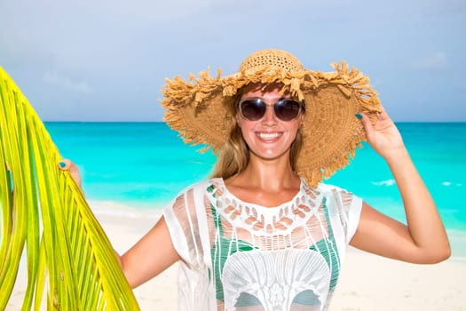Gorgeous woman with sun hat on the dream beach