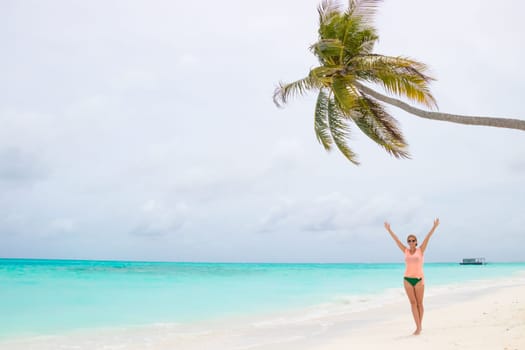 Gorgeous woman on the sandy beach with turquoise ocean