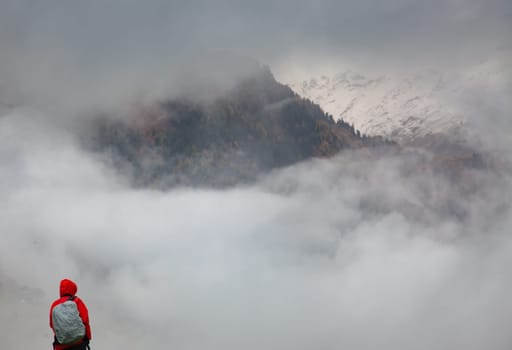 traveler in red against misty mountain peak