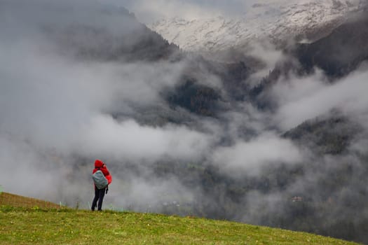 traveler in red against misty mountain peak
