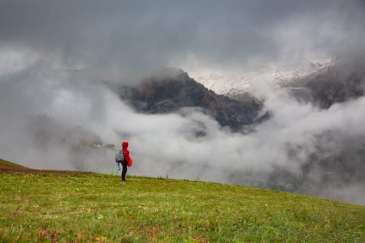 traveler in red against misty mountain peak