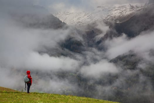 traveler in red against misty mountain peak