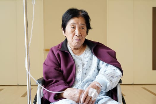 Senior or elderly woman sitting on wheelchair in hospital