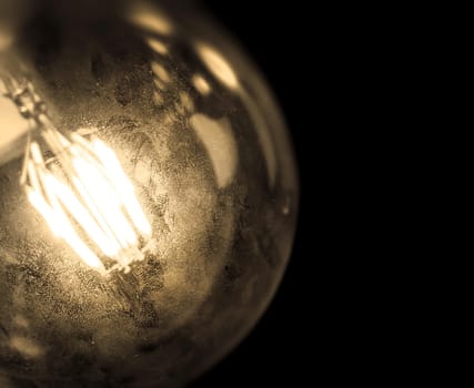 Vintage light bulb for decoration and styling of interiors on dark background. Space for creative text.