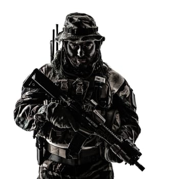 Special forces United States in Camouflage Uniforms studio shot. Holding weapons, wearing jungle hat, Shemagh scarf, painted face, he is ready to kill. Dark contrast