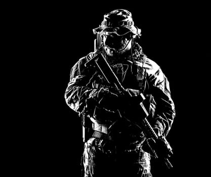 Bearded Special forces United States in Camouflage Uniforms studio shot half length. Holding weapons, wearing jungle hat, Shemagh scarf, he is ready to kill. Contour shot, backlit
