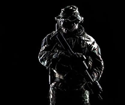 Bearded Special forces United States in Camouflage Uniforms studio shot half length. Holding weapons, wearing jungle hat, Shemagh scarf, he is ready to kill. Contour shot, backlit