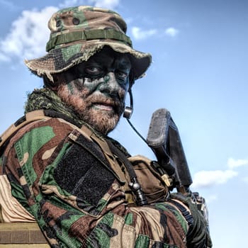 Bearded soldier of special forces on blue sky background