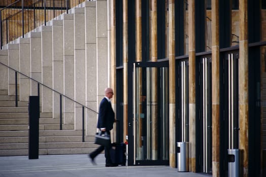 Wiesbaden, Germany - September 25, 2018: A businessman and visitor goes with a suitcase to the Rhein Main Congress Center on September 25, 2018 in Wiesbaden..