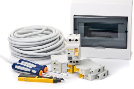 Automatic circuit breakers, distribution box, cable and digital tester on a white background. Electrical equipment. Accessories for electrical protection and control