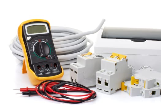 Automatic circuit breakers, distribution box, cable and digital multimeter on a white background. Electrical equipment. Accessories for electrical protection and control