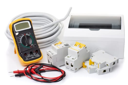 Automatic circuit breakers, distribution box, cable and digital multimeter on a white background. Electrical equipment. Accessories for electrical protection and control