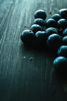 many fresh plums on black background close up.
