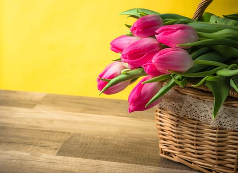 Beautiful bouquet of pink tulips in a wicker basket
