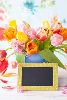 Bunch of fresh colorful tulips and y chalkboard with copy space