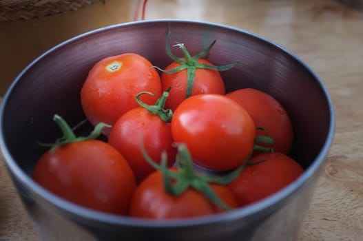 Close up view Tomatoes in metal bowl.