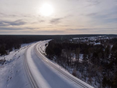 Aerial drone photo of railway in winter forest